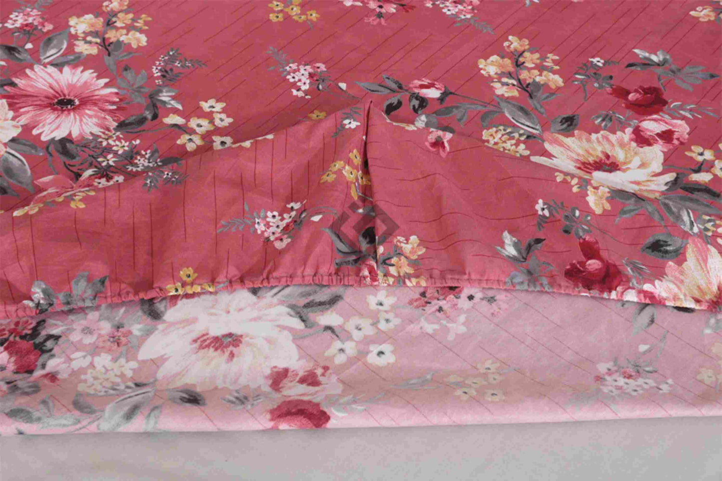 Floral-patterned bedspread on a bed with a red background